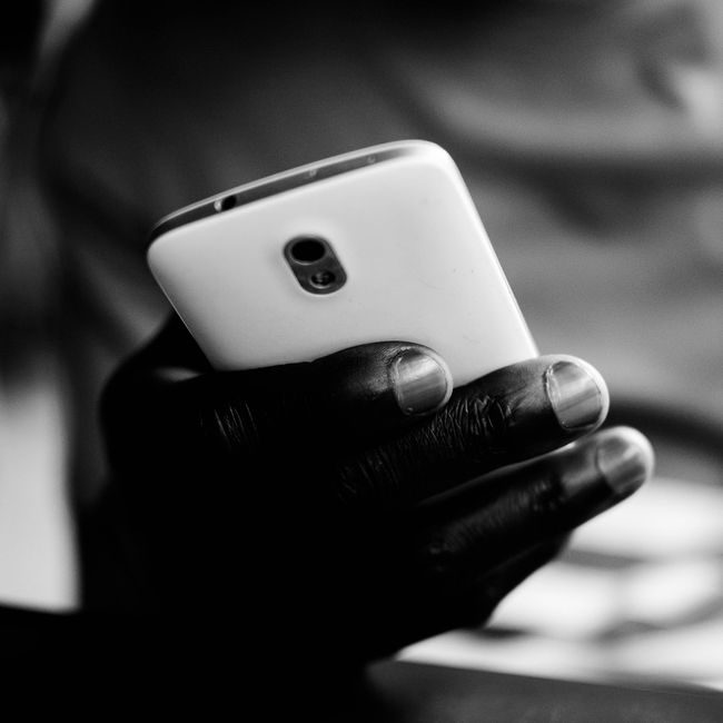 Black and white image of a hand gripping a smartphone with a focus on technology. — Mwabonje Ringa, Pexels
