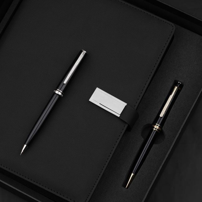 Close-up of a luxurious pen and notebook set arranged on a textured black surface. — The Glorious  Studio, Pexels