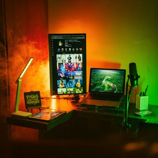 A vibrant home office space with a vertical monitor, laptop, and creative lighting. — Kenneth Surillo, Pexels