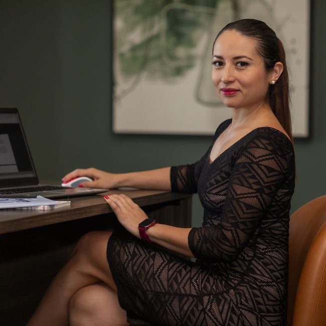 Confident businesswoman in stylish dress working on a laptop at her desk. — andres Nino, Pexels
