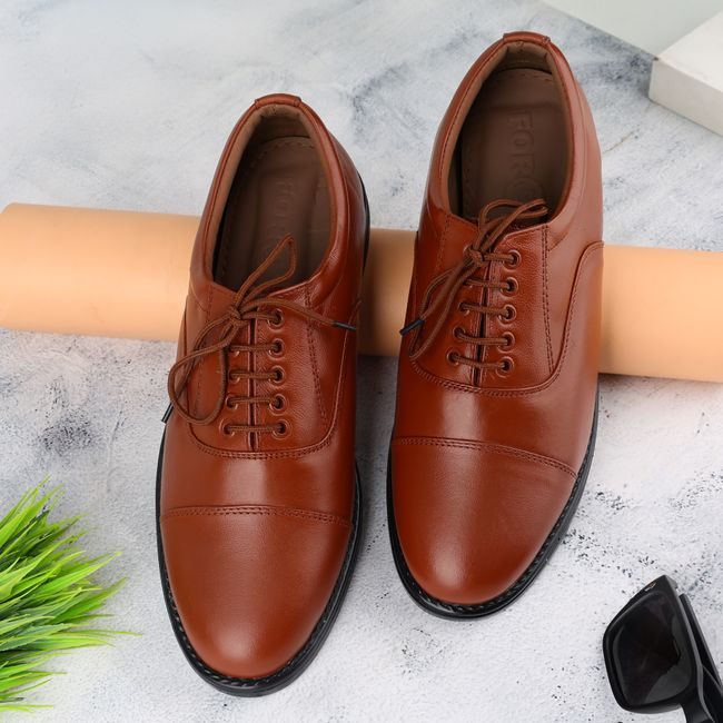 Elegant pair of tan leather shoes on a textured marble surface, ideal for fashion enthusiasts. — ALOK DAS, Pexels