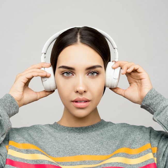 Stylish woman wearing wireless headphones, enjoying music. Captured indoors. — Sound On, Pexels