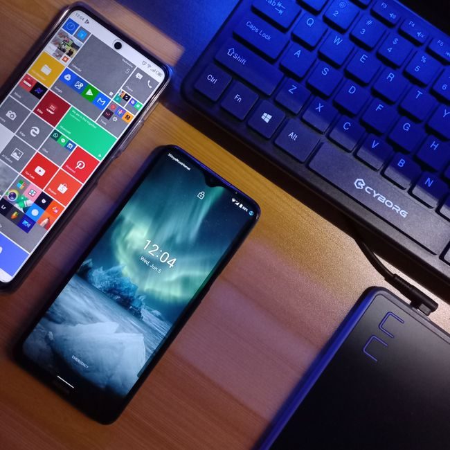 Two smartphones alongside a keyboard on a wooden desk showcasing technology. — Yosi Ariyanda, Pexels