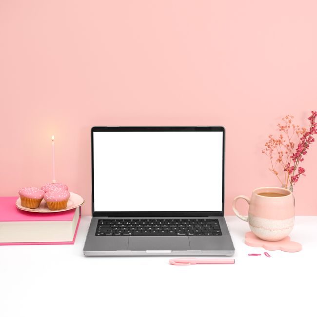 A pink aesthetic workspace featuring a laptop mockup, cupcakes, and a coffee mug for a creative office setup. — Jilly Noble, Pexels