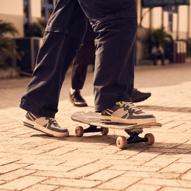 A skateboarder wearing sneakers skateboarding on a sunny day outdoors. — Success ikeomu, Pexels