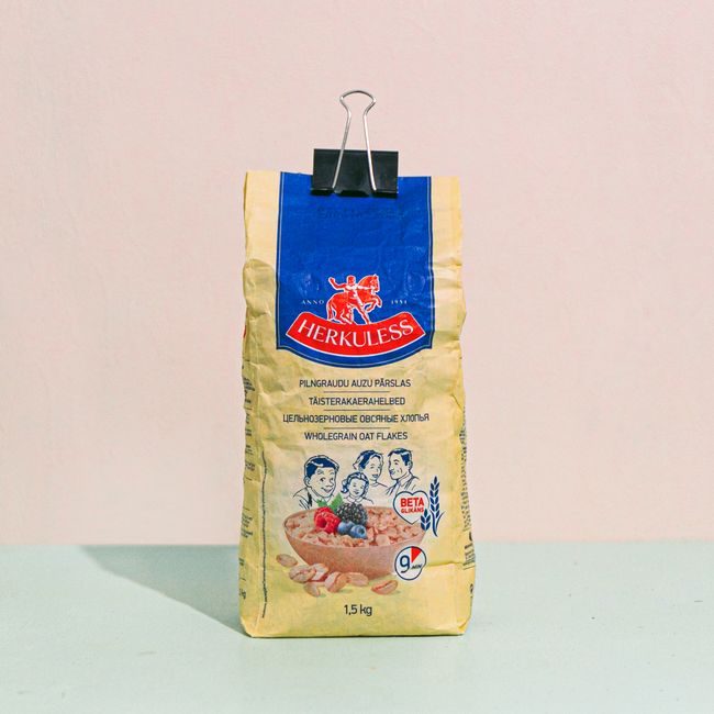 Pack of Herkuless wholegrain oat flakes secured with a binder clip on a pastel background. — Elīna Arāja, Pexels