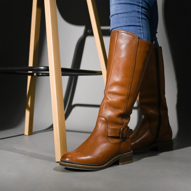 Stylish brown leather boots paired with jeans in a modern indoor scene. — José Martin Segura Benites, Pexels