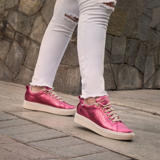 Close-up of pink sneakers and ripped white pants on pavement, modern fashion style. — José Martin Segura Benites, Pexels