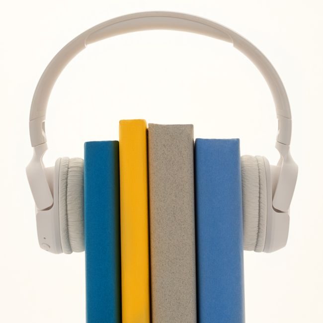 Creative concept of books wearing headphones, symbolizing audiobooks or learning. — Sound On, Pexels