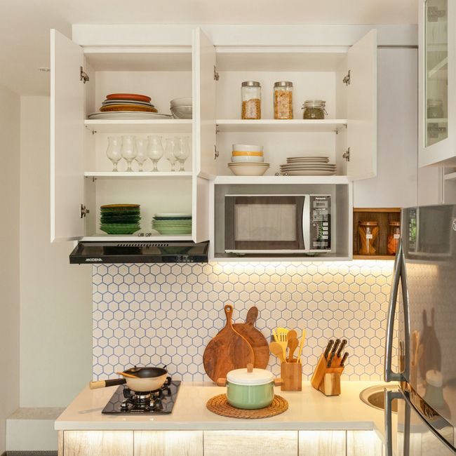 A stylish kitchen showcasing open cabinets with dishes, cookware, and modern appliances. — Hakim  Santoso, Pexels