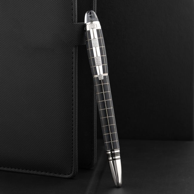 Close-up of a stylish pen held by a textured notebook against a sleek black background, ideal for corporate imagery. — The Glorious  Studio, Pexels