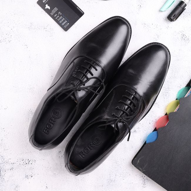 Top view of black leather Oxford shoes surrounded by office essentials, ideal for business and fashion themes. — ALOK DAS, Pexels