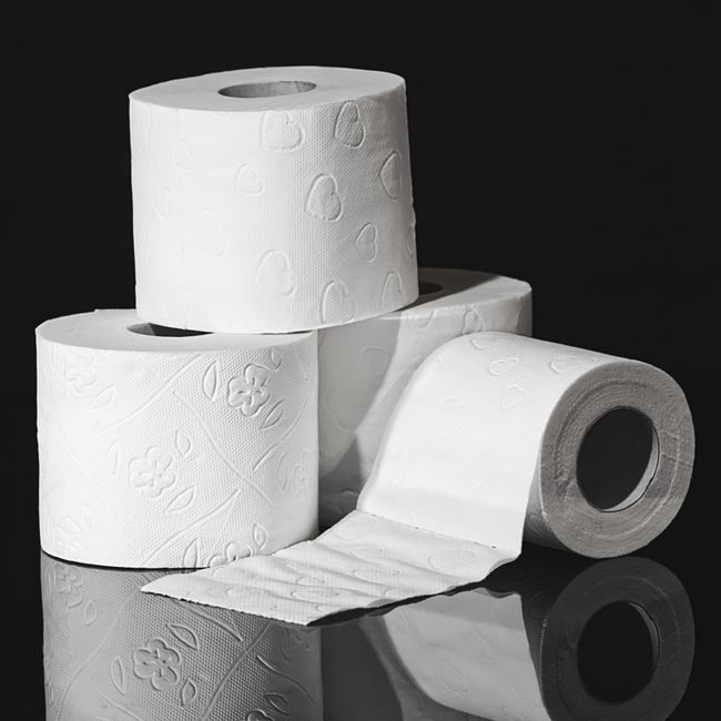 High-quality close-up image of stacked toilet paper rolls against a black background. — Alexas Fotos, Pexels