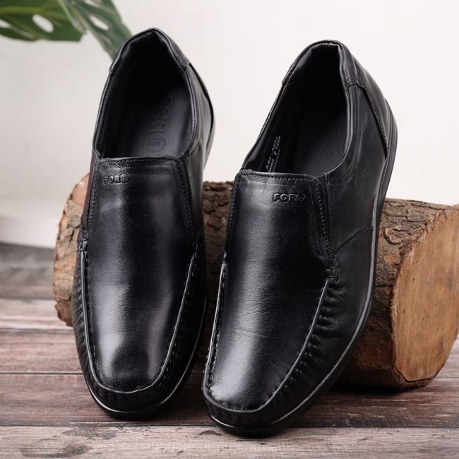 High-quality black leather shoes placed on a rustic wooden log for a classy fashion display. — ALOK DAS, Pexels