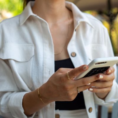 Close-up of a woman in casual attire using a smartphone, showcasing modern lifestyle and technology. — archisude, Pexels