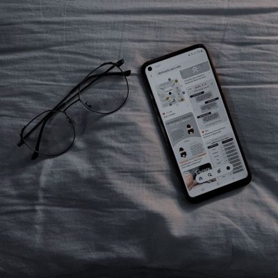 A smartphone and eyeglasses resting on a bedspread, creating a casual still life scene. — Gabriel  Albino De Jesus, Pexels