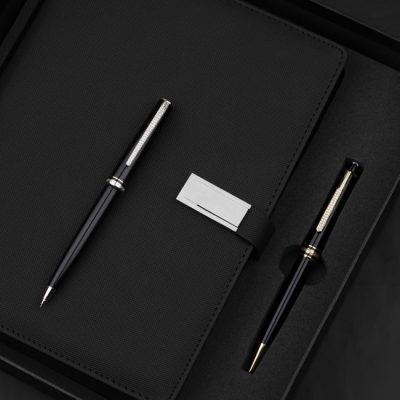 Close-up of a luxurious pen and notebook set arranged on a textured black surface. — The Glorious  Studio, Pexels