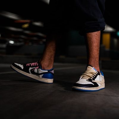 Fashion-forward sneakers captured on a man's feet in a dimly lit setting, showcasing streetwear style. — Ali Dashti, Pexels