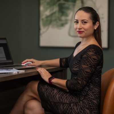 Confident businesswoman in stylish dress working on a laptop at her desk. — andres Nino, Pexels