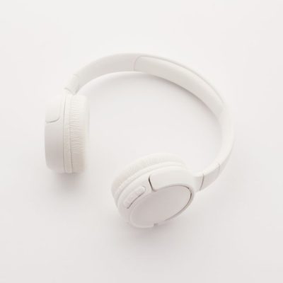 Sleek overhead view of modern white wireless headphones on a clean white background. — Sound On, Pexels