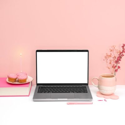 A pink aesthetic workspace featuring a laptop mockup, cupcakes, and a coffee mug for a creative office setup. — Jilly Noble, Pexels