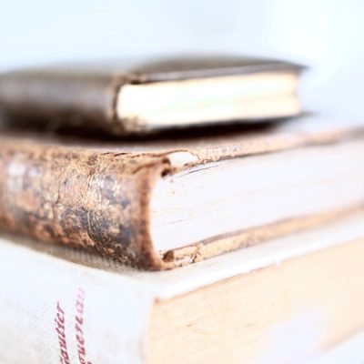 Closeup stack of old weathered books with white aged sheets in hardcover on blue background — Jess Bailey Designs, Pexels