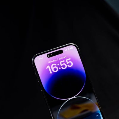 Sleek modern smartphone displaying time against a black background in vertical orientation. — Kafeel Ahmed, Pexels