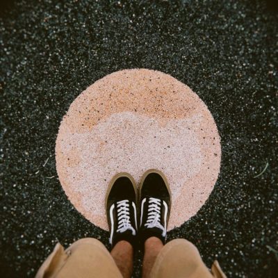 Top view of casual sneakers on an abstract circular surface outdoors. — Alejandro Robles Duque, Pexels