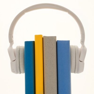 Creative concept of books wearing headphones, symbolizing audiobooks or learning. — Sound On, Pexels
