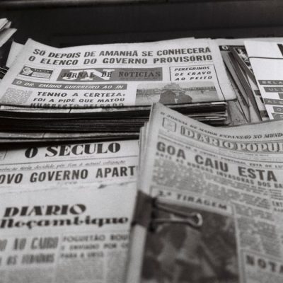 A nostalgic view of vintage Portuguese newspapers stacked together, showcasing historical headlines. — Efe Ersoy, Pexels