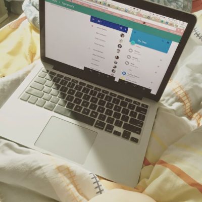 A laptop showing a social media interface on a bed, top view, showcasing technology use in a cozy setting. — Kailani Mak, Pexels