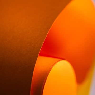 Abstract image of curved orange paper with a soft gradient and elegant flow. Perfect for backgrounds and creative design concepts. — Jakub Zerdzicki, Pexels